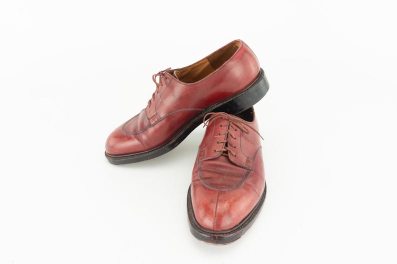 May include: A pair of burgundy leather lace-up shoes. The shoes have a pointed toe and a low heel.