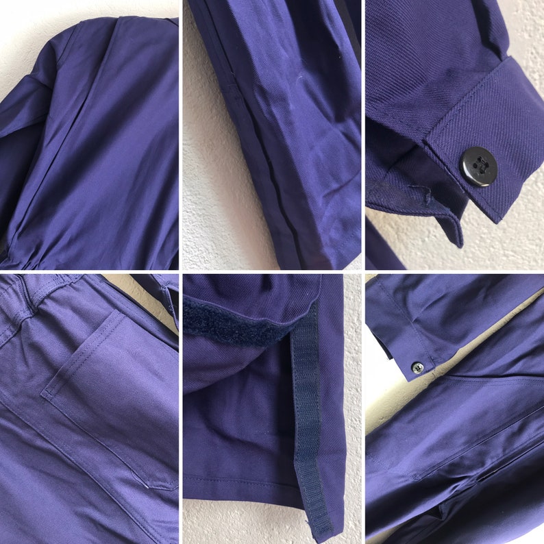 Pu&ograve; includere: Primo piano di una tuta blu scuro con cerniera e una tasca sul davanti. La tuta ha un elastico nero in fondo alle gambe e una fascia in velcro nera all'interno delle gambe.