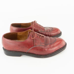May include: A pair of burgundy leather lace-up shoes. The shoes have a classic design with a pointed toe and a low heel.