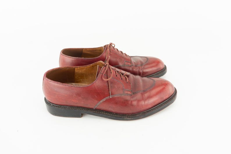 May include: A pair of burgundy leather lace-up shoes. The shoes have a classic design with a pointed toe and a low heel.