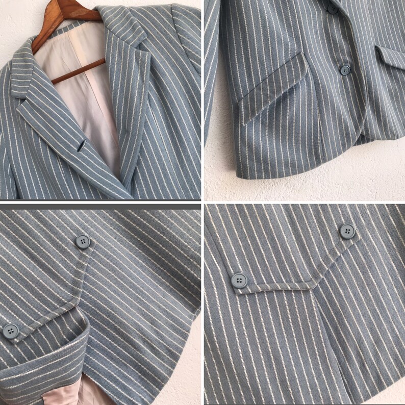 Puede incluir: Una chaqueta azul claro con rayas blancas. La chaqueta tiene cierre de doble botonadura con botones y un bolsillo en el lado izquierdo.