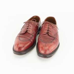 May include: A pair of brown leather lace-up shoes with a wingtip design.