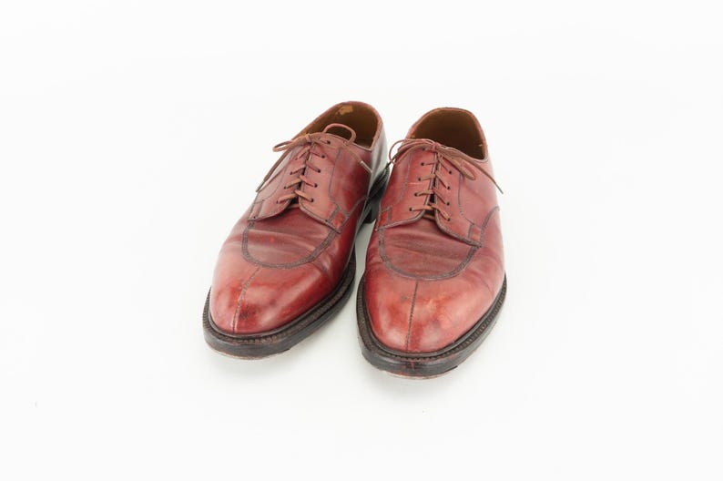 May include: A pair of brown leather lace-up shoes with a wingtip design.