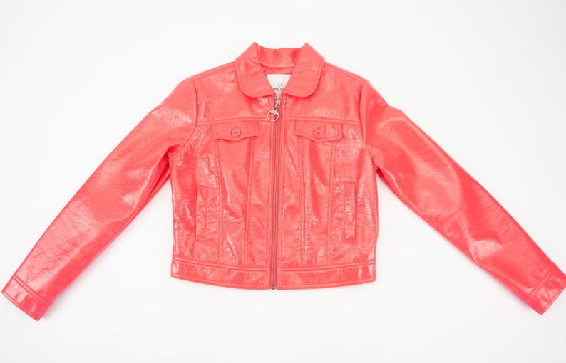 May include: A bright pink faux leather jacket with a zipper closure and two flap pockets. The jacket has a shiny finish.