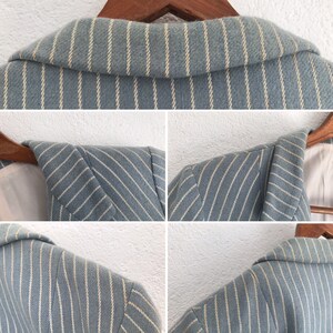 Puede incluir: Una chaqueta azul claro con rayas blancas. La chaqueta tiene un cuello de muesca y un cierre de un solo bot&oacute;n. La tela es suave y tejida.