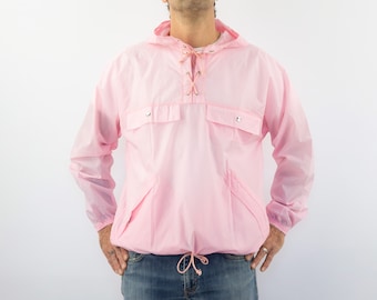 Könnte beinhalten: Eine rosafarbene Kapuzenjacke mit Kordelzug an der Taille und zwei Taschen. Die Jacke hat einen Schnürverschluss am Hals.