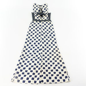 May include: A white maxi dress with a black belt and a blue and white checkered pattern.
