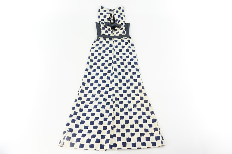 May include: A white maxi dress with a black belt and a blue and white checkered pattern.