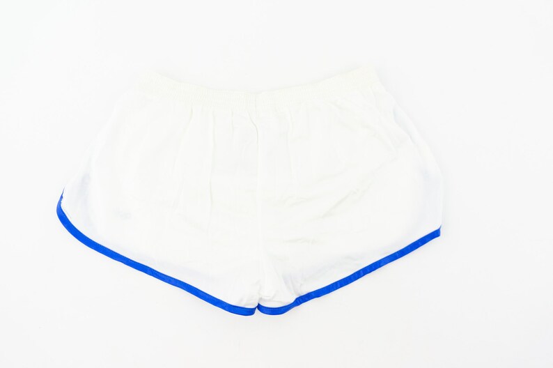 May include: White athletic shorts with a blue trim around the edges.
