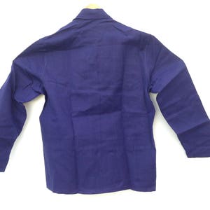 May include: A long-sleeved, solid blue work shirt with a button-up collar.