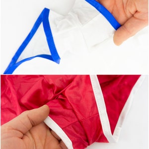 May include: Two pairs of underwear with contrasting trim. One pair is white with blue trim, and the other is red with white trim.