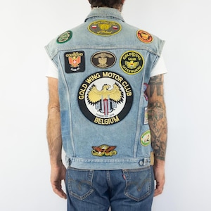 May include: A blue denim vest with various patches, including a large circular patch with the text "Gold Wing Motor Club Founded 1978 Belgium".
