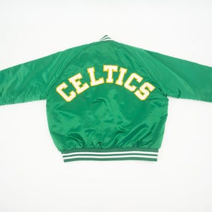 May include: Green satin bomber jacket with white and green striped trim. The back of the jacket has the word "CELTICS" in yellow lettering.