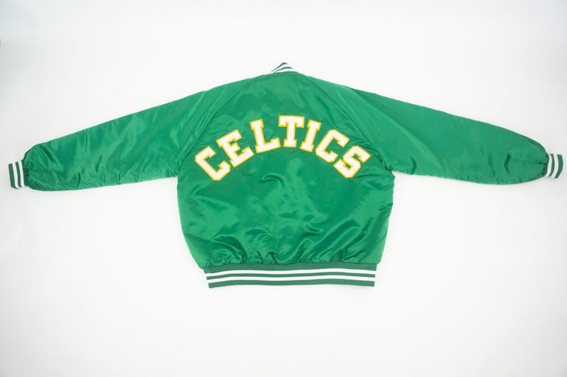 May include: Green satin bomber jacket with white and green striped trim. The back of the jacket has the word "CELTICS" in yellow lettering.