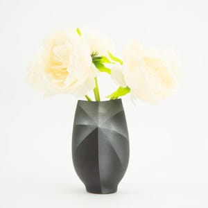 Peut inclure: Une tasse en céramique blanche avec une anse noire et l'inscription "But First, Coffee" en gras noir. La tasse est posée sur un fond neutre, soulignant son design simple.