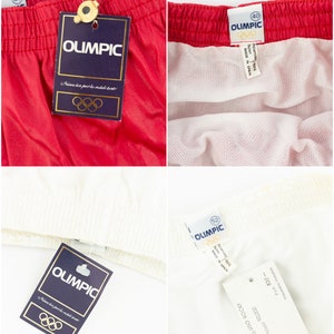 May include: Red and white athletic shorts with a blue tag that says "OLIMPIC" and features the Olympic rings. The tag says "Alumea tan peve ha restule hante".