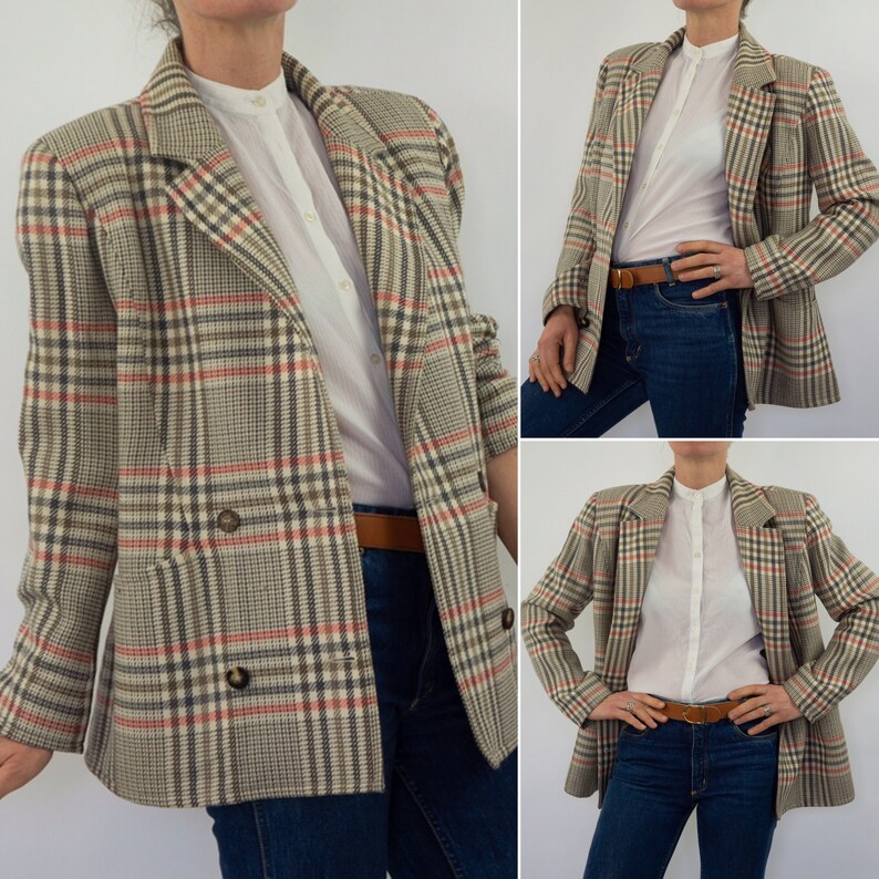 Pu&ograve; includere: Un blazer a quadri beige, marrone, rosso e nero. La giacca doppiopetto ha due file di bottoni e un revers a lancia. &Egrave; abbinato a una camicia bianca con colletto, jeans blu e una cintura marrone.