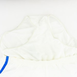 May include: White athletic shorts with a blue stripe down the side. The shorts have a built-in liner.