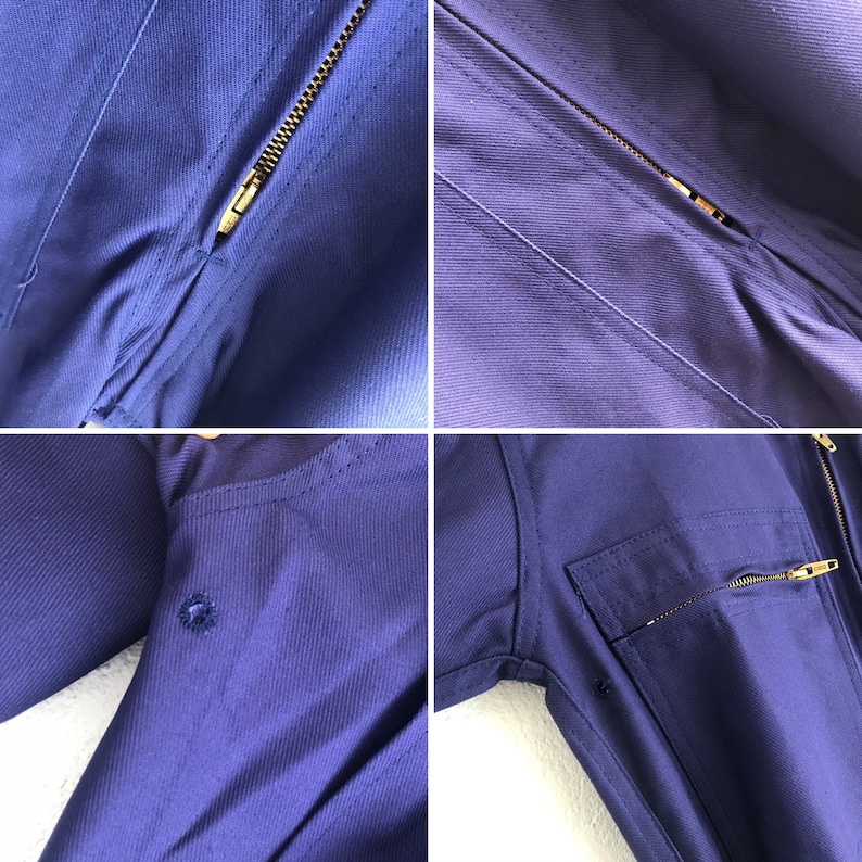 Pu&ograve; includere: Una tuta da lavoro blu scuro con chiusura a zip e pi&ugrave; tasche. La tuta ha un tessuto strutturato e una zip dorata a contrasto.
