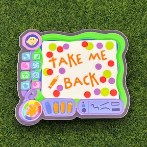 以下が含まれることがあります： 白い背景にオレンジ色の「TAKE ME BACK」の文字が入ったカラフルなステッカー。緑色の縁取りがあり、カラフルなドットと鉛筆のイラストが描かれた漫画風のデザインです。