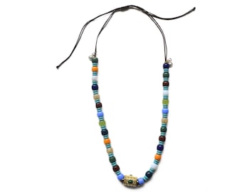 May include: A colorful beaded necklace with a gold charm. The beads are blue, green, orange, and brown.