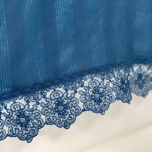 May include: A blue fabric with a silver glitter stripe pattern and a black lace trim.
