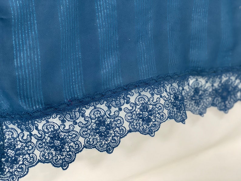 May include: A blue fabric with a silver glitter stripe pattern and a black lace trim.