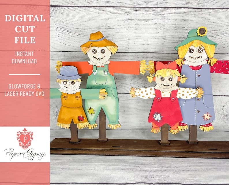 May include: A set of four scarecrow figures, two adults and two children, standing on a wooden base. The scarecrows are dressed in overalls, dresses, and hats. They have painted faces with cross-stitched eyes and mouths. The scarecrows are made of wood and fabric.