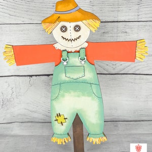 May include: A friendly scarecrow with a straw hat, orange shirt, and blue overalls. The scarecrow has a stitched-on smile and X's for eyes. The scarecrow is standing on a wooden stake.
