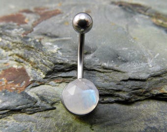 May include: A silver belly button ring with a round, white moonstone gem.