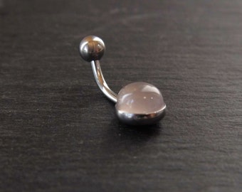 May include: A silver belly button ring with a clear pink gem stone.