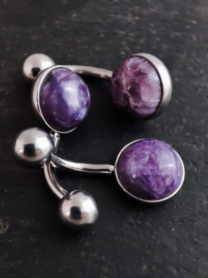 3, 8mm purple charoite cabochon set in a polished 316l steel belly bar on a slate background