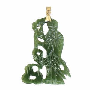 Peut inclure: Pendentif en jade vert avec un motif de figurine sculptée. Le pendentif est doté d'une bélière dorée en haut pour l'accrocher. Le jade est d'un vert translucide avec des détails complexes sculptés dans la pierre. Le pendentif est un bijou unique.