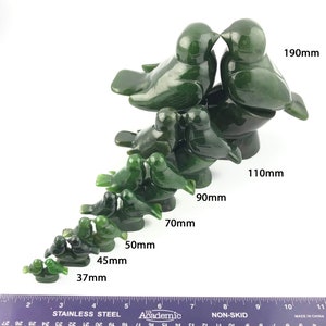 Puede incluir: Un conjunto de 10 esculturas de p&aacute;jaros de jade verde, que van desde los 37 mm hasta los 190 mm. Los p&aacute;jaros est&aacute;n dispuestos en una formaci&oacute;n en cascada, con el p&aacute;jaro m&aacute;s grande en la parte superior y el p&aacute;jaro m&aacute;s peque&ntilde;o en la parte inferior.