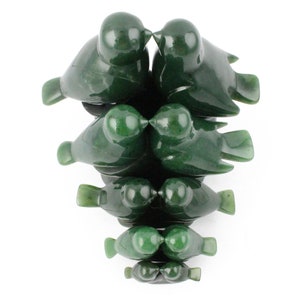 Puede incluir: Un conjunto de siete esculturas de p&aacute;jaros de jade verde, cada una de un tama&ntilde;o diferente, dispuestas en una pila con los p&aacute;jaros m&aacute;s grandes en la parte superior y los m&aacute;s peque&ntilde;os en la parte inferior. Los p&aacute;jaros est&aacute;n tallados en un estilo realista y tienen sus picos toc&aacute;ndose, como si se estuvieran besando.