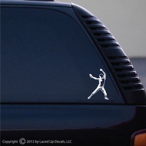 May include: White vinyl decal of a baseball pitcher in mid-throw, applied to a dark blue vehicle window. The decal shows the baseball player in action, with arms extended. Copyright 2013 by Laced Up Decals, LLC.