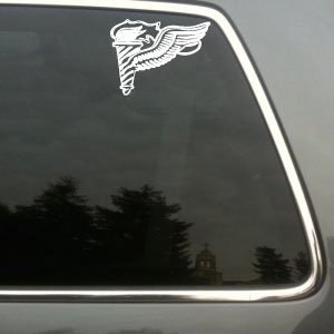 May include: White vinyl decal of a winged torch, likely for a vehicle window. The design features a detailed torch with flames and a stylized wing. The decal is applied to a car window, with a blurred outdoor background visible.