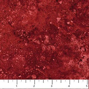 Puede incluir: Primer plano de una tela roja con un aspecto moteado y texturizado. La tela tiene una base roja oscura con reflejos rojos y rosados más claros, que se asemejan a un patrón de piedra o geológico. Una regla está en la parte inferior, mostrando medidas en centímetros.