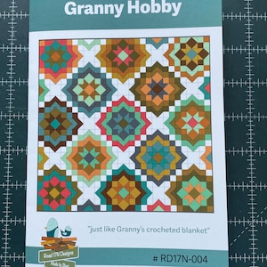 May include: A printed pattern booklet titled Granny Hobby featuring a colourful geometric quilt design with squares in shades of orange, teal, brown, and pink. The cover includes the text just like Granny's crocheted blanket and # RD17N-004.