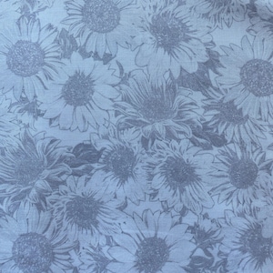 May include: White fabric with a grey floral pattern of sunflowers. The fabric has text that reads "Sunflower Whispers 108" BY GRETA LYNN  www.benartex.com