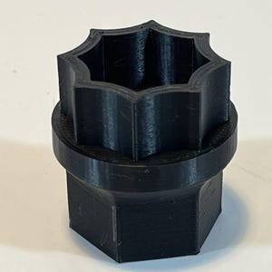 May include: A black plastic 3D printed socket wrench with a 7-point star shape.