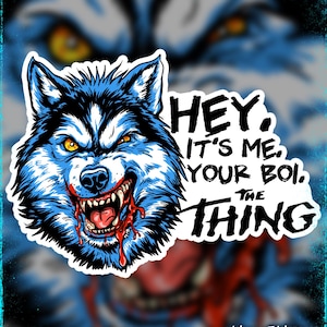 Könnte beinhalten: Ein Aufkleber mit einem grimmigen Wolf mit blauem und schwarzem Fell, gelben Augen und Blut. Der Text lautet "HEY, IT'S ME, YOUR BOI, THE THING." Der Hintergrund zeigt ein verschwommenes Wolfsbild.