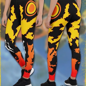 May include: Black leggings with a vibrant yellow and orange flame-like design. The leggings feature a large orange circle with a yellow center on the upper thigh. The bottom of the leggings are red. The text "Midnight Monster" is visible.