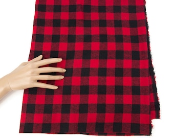 May include: Red and black plaid fabric with a slightly frayed edge.