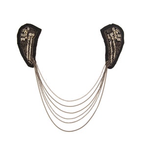 May include: A black fabric collar with gold chain embellishments. The collar has a pointed shape and is decorated with gold beads and chains.