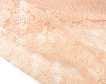 May include: Peach-colored lace fabric with a delicate floral pattern. The lace is soft and sheer, with a subtle shimmer.