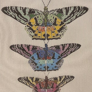 May include: Three colorful butterflies with black and white striped wings. The top butterfly is yellow, green, and blue. The middle butterfly is blue, purple, and pink. The bottom butterfly is pink, yellow, and orange.