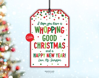 Op de afbeelding: Een kerstcadeaulabel met een rode rand en een zwart touwtje. Het label heeft de tekst "I hope you have a WHOPPING GOOD CHRISTMAS and a HAPPY NEW YEAR!" in groen en rood. De tekst "Love, Ms. Sampson" staat er ook op.
