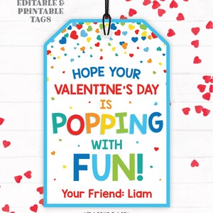 Puede incluir: Una etiqueta de regalo para el D&iacute;a de San Valent&iacute;n, imprimible, azul y blanca, con corazones y confeti de colores. La etiqueta dice "&iexcl;Espero que tu D&iacute;a de San Valent&iacute;n est&eacute; lleno de diversi&oacute;n!" y "Tu amigo: Liam".
