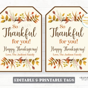 May include: Two printable Thanksgiving gift tags with a fall foliage design. The tags are beige with brown borders and feature the text "So Thankful for you! Happy Thanksgiving! Love, The Jackson Family".